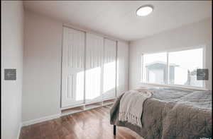 Bedroom with wood-type flooring and baseboards