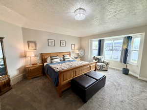 Bedroom with a textured ceiling and carpet flooring