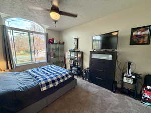 Bedroom featuring a textured ceiling, carpet floors, and ceiling fan