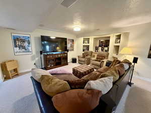Living room featuring carpet flooring and a textured ceiling