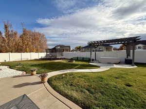 Fenced backyard featuring a trampoline, a patio area, a pergola, and a jacuzzi