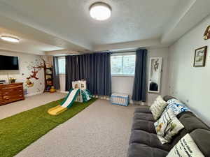 Game room with carpet floors and a textured ceiling