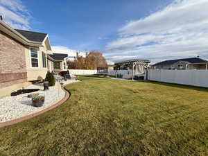 Fenced backyard featuring a patio area, a pergola, and a trampoline