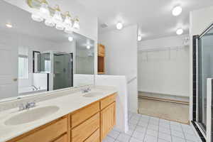 Full bathroom with a stall shower, light tile patterned floors, double vanity, a bath, and a spacious closet