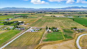 Aerial view of property and surrounding area featuring a mountain backdrop and rural landscape