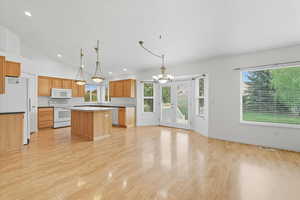 Kitchen with a chandelier, a kitchen island, decorative light fixtures