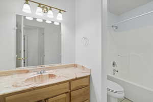 Bathroom featuring washtub / shower combination, vanity, and tile patterned flooring