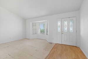 Entrance foyer featuring light wood-type flooring and lofted ceiling