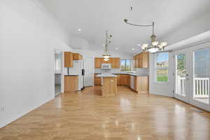Kitchen with a center island, healthy amount of natural light, a chandelier, light wood-style flooring, and recessed lighting