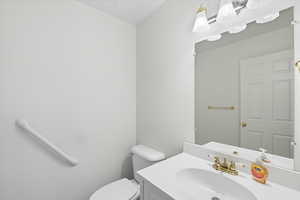 Half bathroom with vanity and toilet