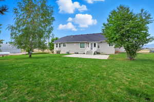 Rear view of house with a patio area and a yard