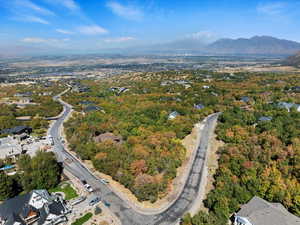 Aerial view of property and surrounding area featuring a mountainous background