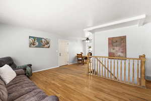 Living area with wood finished floors and ceiling fan