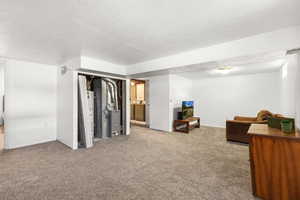 Bedroom with a textured ceiling, carpet, and heating unit