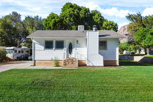 View of front of house featuring a chimney and a shingled roof