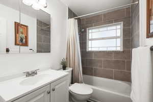 Full bathroom featuring shower / tub combo with curtain and vanity