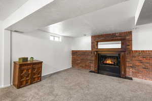 Living room with a fireplace, a textured ceiling, and carpet floors
