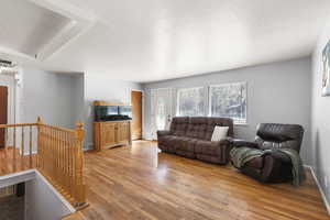 Living area featuring light wood-style floors and a textured ceiling