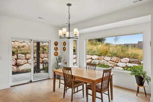 Dining room featuring light wood-style flooring, plenty of natural light, and a chandelier