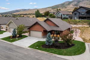 Craftsman-style home featuring stone details, a mountain view, flat driveway, and a 2-car garage