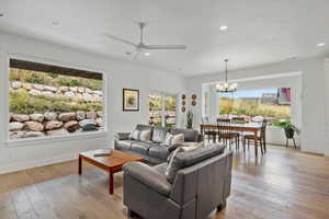 Spacious living area with light wood flooring, picture windows, sliding glass door, and healthy amount of natural light