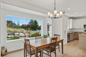 Dining room with light wood-style flooring, a chandelier, and recessed lighting