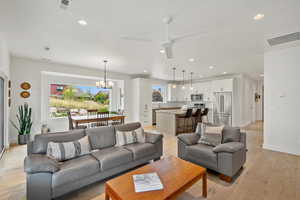 Living area featuring light wood-style flooring, a chandelier, recessed lighting, and ceiling fan