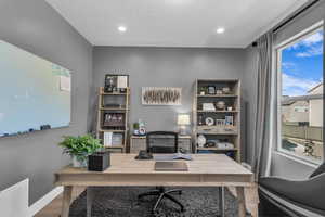 Home office with wood finished floors, a textured ceiling, and recessed lighting
