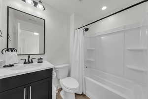 Full bath with vanity, shower / tub combo, light wood finished floors, and recessed lighting
