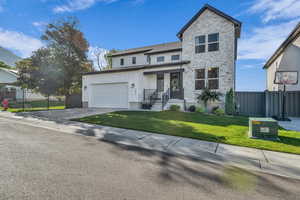 Traditional-style home with stone siding, driveway, and board and batten siding