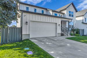 View of front facade with stone siding, concrete driveway, and board and batten siding