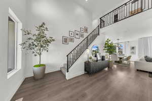 Staircase with a high ceiling and wood finished floors