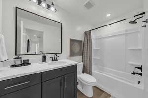 Full bathroom featuring shower / tub combo with curtain, light wood-type flooring, vanity, and recessed lighting