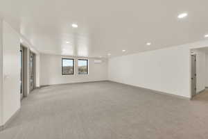 Daylight basement recreation room with French doors leading to patios and hot tub area.