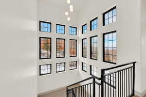 Staircase featuring a towering ceiling and natural light.