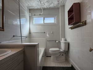 Full bath featuring tile walls, vanity, a garden tub, and a shower