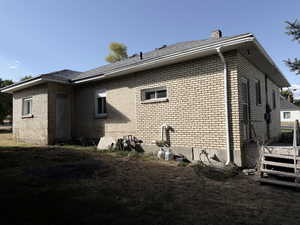 View of side of property with brick siding and a chimney