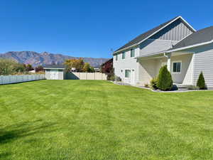 Fenced backyard with a shed and a mountain view