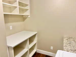 Laundry area featuring baseboards and dark wood finished floors