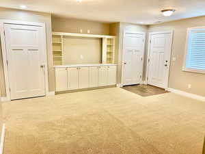 Unfurnished living room with light colored carpet, a textured ceiling, and recessed lighting