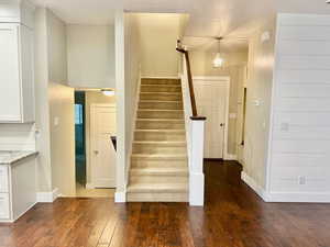 Stairs with hardwood / wood-style floors and baseboards