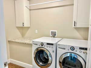 Washroom featuring cabinet space and washing machine and clothes dryer