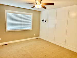 Unfurnished bedroom with light carpet and a ceiling fan