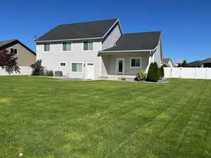 Back of property featuring a fenced backyard, a patio area, and a shingled roof