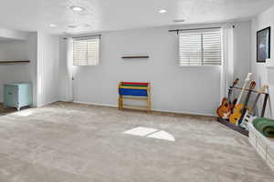 Basement open family room with a textured ceiling, carpet flooring, and recessed lighting