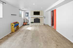 Unfurnished living room with carpet flooring, a fireplace, recessed lighting, and a textured ceiling