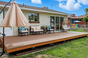 Rear view of house with a deck and brick siding