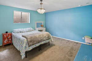Bedroom featuring carpet and a chandelier