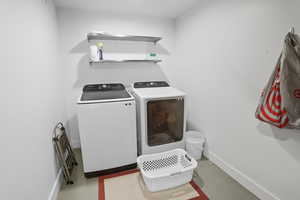 Laundry area with baseboards and washing machine and dryer