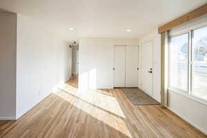 Entryway with light wood-type flooring and recessed lighting